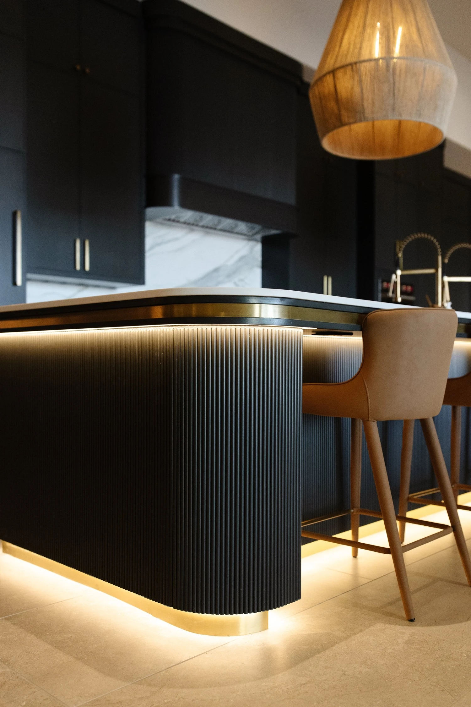 Curved black island with white oak bar by Warner Cabinets