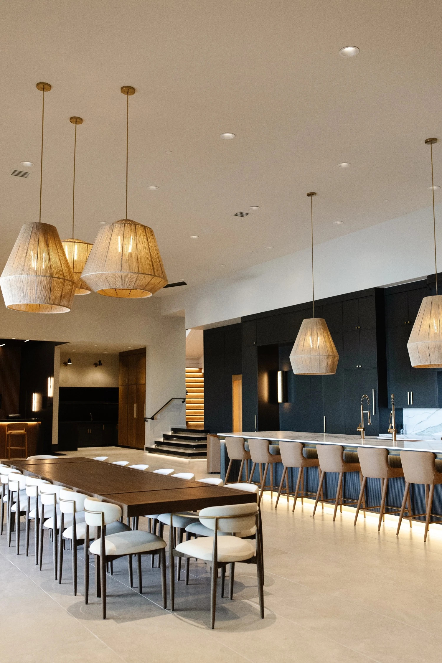 Black and white oak custom kitchen with bar seating and brass pendants by Warner Cabinets